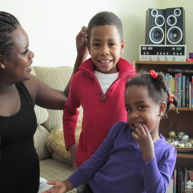 Jackie and her family sit in the living room of their new home